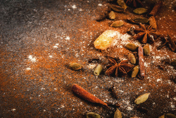 Mixture of dried ground spies for hot spicy tea or indian masala chai - cinnamon, anise, cardamom, ginger, on a white marble table - chili, paprika, curry, turmeric, ginger. Copy space