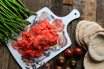 Closeup of thinly sliced smoked salmon on wooden board