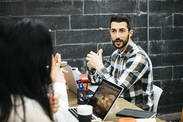 Creative people chatting at workplace