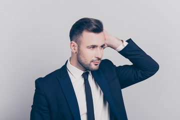 Portrait of half turned stunning ideal boss touching his hair looking to the side over grey background