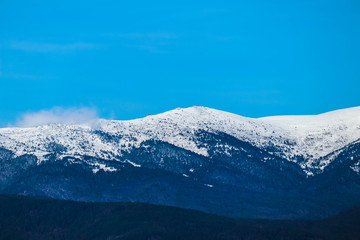 Fototapeta na wymiar Mountain snow peak, beautiful natural winter backdrop. Ice top of the hill, blue sky background. Alpine landscape.