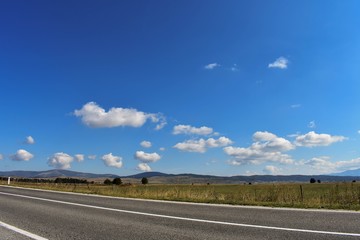 Fototapeta premium Open road through beautiful countryside, landscape travel photography