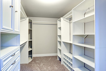 Fototapeta na wymiar Narrow walk-in closet lined with built-in drawers