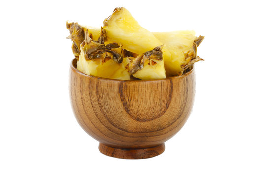 slices of pineapple in wooden cup isolated