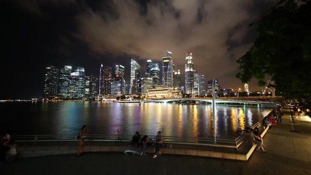 Singapore - November 27, 2017: Zoom in timelapse footage of Singapore cityscape with skyscrapers and colorful light at night. Shot in 4k resolution