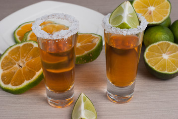 Tequila with lemon and salt on the wooden background