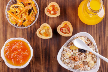 Healthy breakfast. Ceramic bowl with oat flakes, dried fruits, nuts on wood background