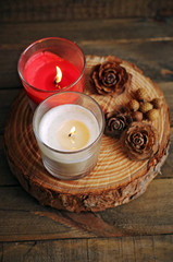 Red and white candle lit on wood