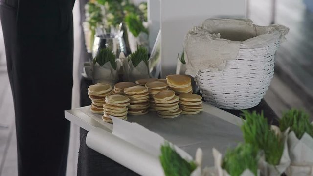 the waiter places pancakes on the table with desserts