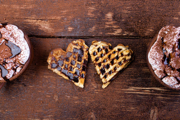 Belgian heart shaped waffle with hot chocolate with marshmallow on wooden background.