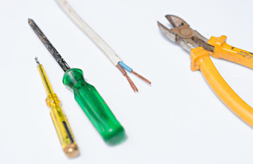Electrical cables sharp wire cutter and screwdriver on white background electricity concept.
