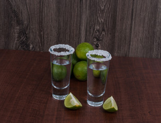Tequila with lemon and salt on the wooden background