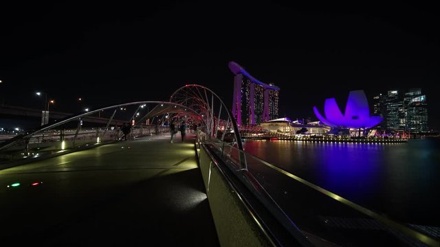 Singapore - November 27, 2017: Timelapse footage of Helix Bridge in Marina Bay Sands Singapore with ArtScience Museum and Marina Bay Sands Hotel view at night. Shot in 4k resolution