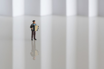 Sailor playing a sad song on his accordion - miniature figure