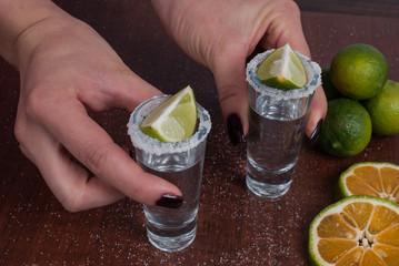 Tequila with lemon and salt on the wooden background