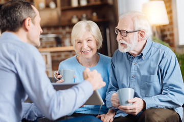 Interesting content. Loving young man talking to his elderly parents and showing him something on...