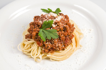 Italian spaghetti pasta with beef and tomato sauce bolognese on white plate