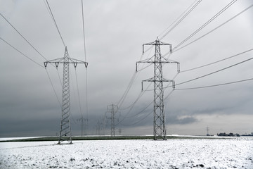 Hochspannungsmasten in verschneiter Landschaft
