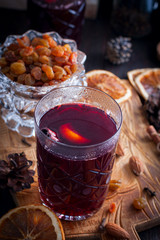 Scandinavian hot alcoholic drink with cinnamon in a glass cup on a wooden board, selective focus
