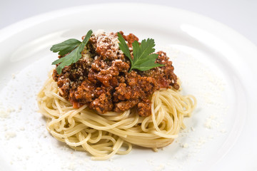 Italian spaghetti pasta with beef and tomato sauce bolognese on white plate