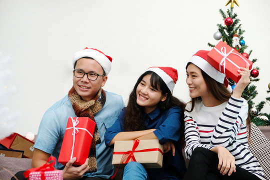 Young asia man and women holding gift boxes with happiness in Christmas party, friends Christmas party celebration