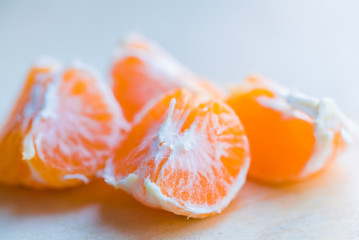 Closeup pieces of peeled tangerine on wooden board