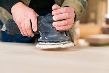 Close up man sanding wood in workshop