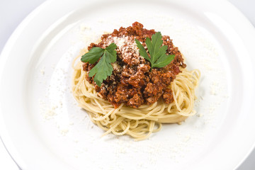 Italian spaghetti pasta with beef and tomato sauce bolognese on white plate