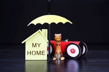 Insurance, an umbrella protects house and car.