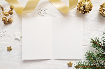 Mockup Christmas greeting card top view and gold star, flatlay on a white wooden background with a ribbon, with place for your text