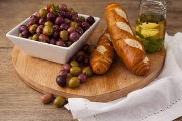 High angle view of olives in container by bread and oil