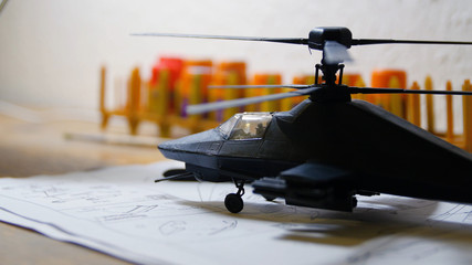 Toy Military Helicopter on wooden table. Small army helicopter hobby model toy on the table. Toy helicopter on the table