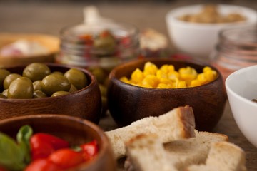 Olives and corns in bowls by ingredients