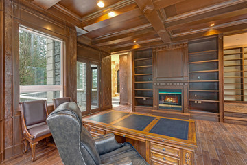 Chic Wood Paneled Home office features coffered ceiling