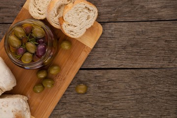 Close up of olives in container by bread