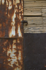 wooden door entrance with metal features.metal rounded hinge on old timber door. stone building with plank door. rusty nails on wood