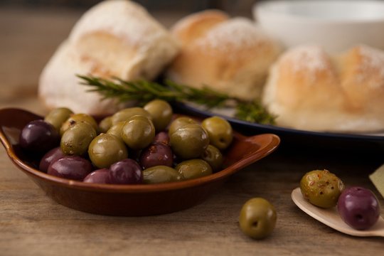 Olives in plate by bread