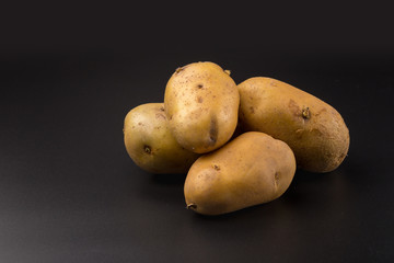 Uncooked fresh potatoes isolated on a Black background