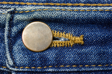 Brass button of vintage blue Jeans. Suitable for backgrounds, articles about fashion clothing.