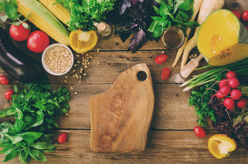 Vegetables on wooden background. Herbs, basil, onion, pumpkin, pine nuts, tomatoes, corn, radish,...