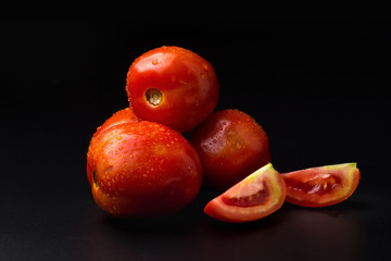 Fototapeta na wymiar Ripe red tomatoes isolated on black background