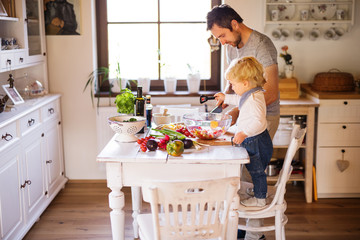 Young father with a toddler boy cooking.