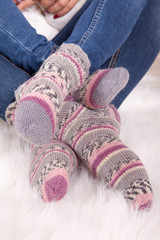 Legs of woman in knitted woolen pink socks. Closeup