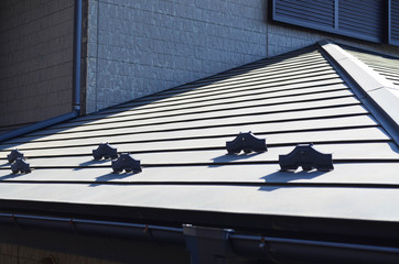 Close up of rain gutter system and roof protection from snow board (snow guard) on house construction