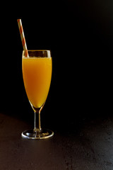 Freshly squeezed orange juice on a dark background.