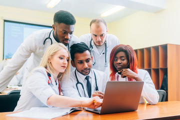 Fototapeta premium Multiracial team of young doctors working on laptop computer in medical office.
