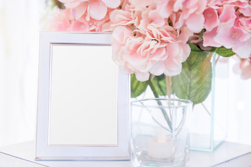 Blank  frame on the table and flower decoration