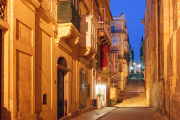 Fototapeta na wymiar Typical Maltese medieval street at night in the center of the Old Town of Valletta, Malta