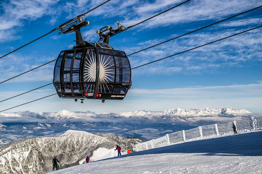 Skiers on the slope. Cableway Funitel in Low Tatras mountains, Slovakia.
