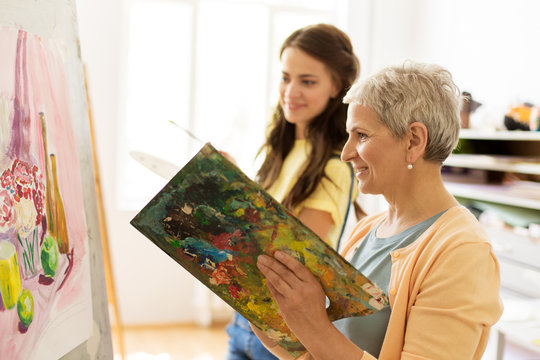 happy women painting at art school studio